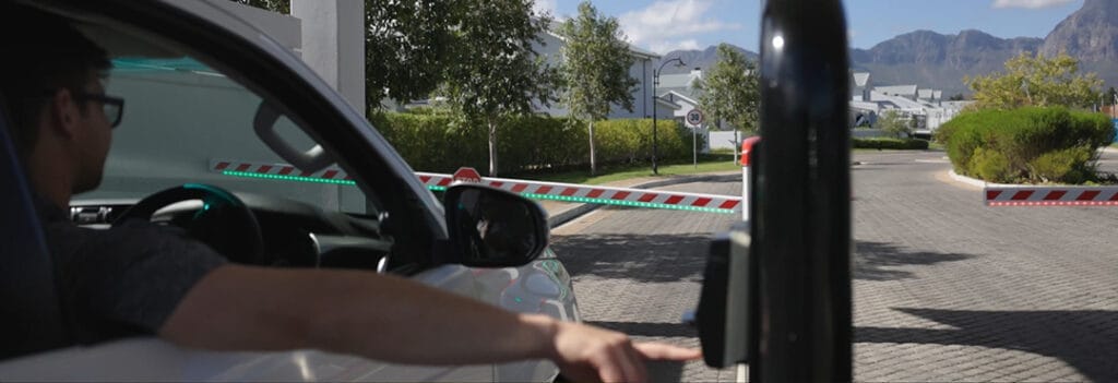 A driver passing through a Centurion SECTOR II Boom Gate in a vehicle, highlighting the gate's robust design and efficient operation.