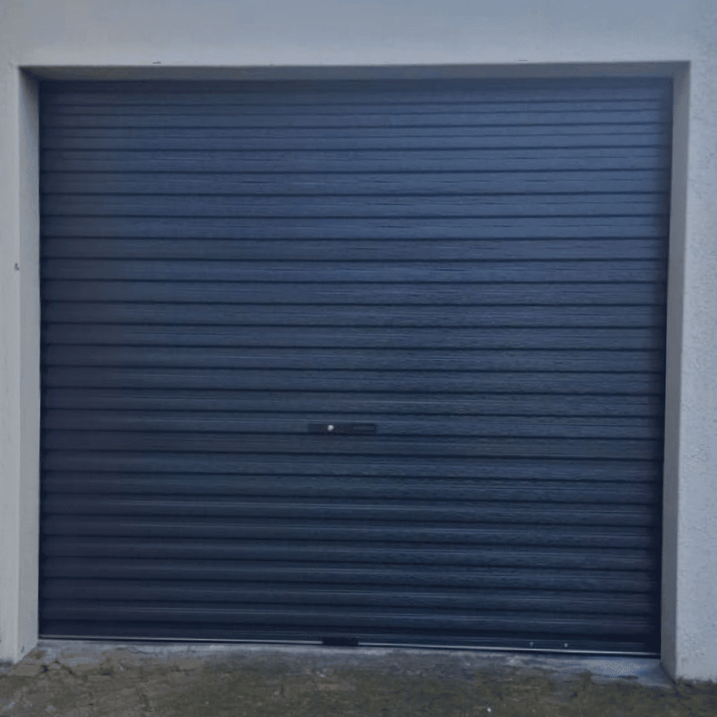 Charcoal Wispeco roll-up garage door installed on a Cape Town home, featuring powder-coated Aluzinc panels and vertical operation for secure, space-saving access.