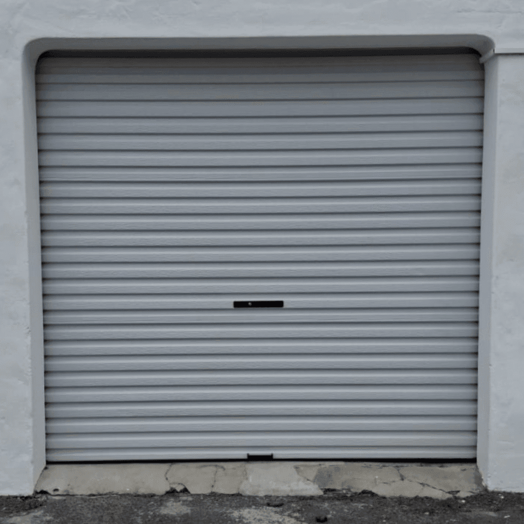 White Wispeco roll-up garage door installed on a Cape Town home, featuring corrosion-resistant Aluzinc panels and vertical operation for space-saving access.
